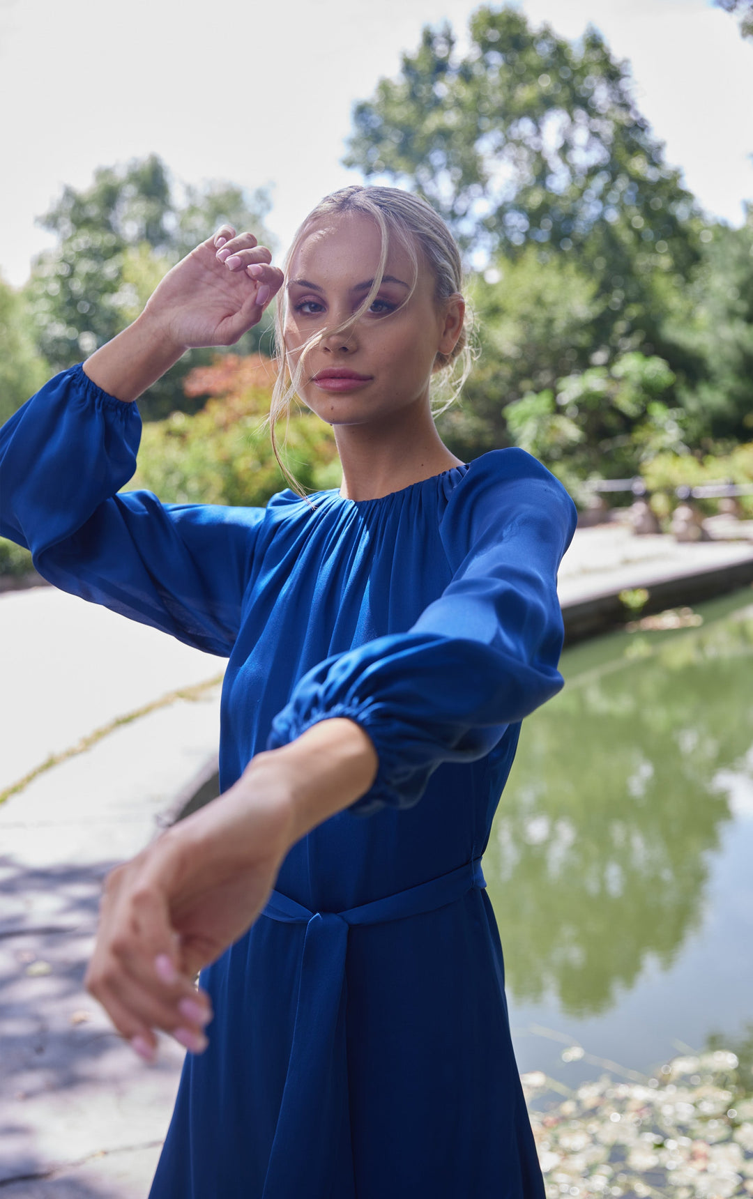 woman outside front view blue puff sleeve silk dress with rusched neck