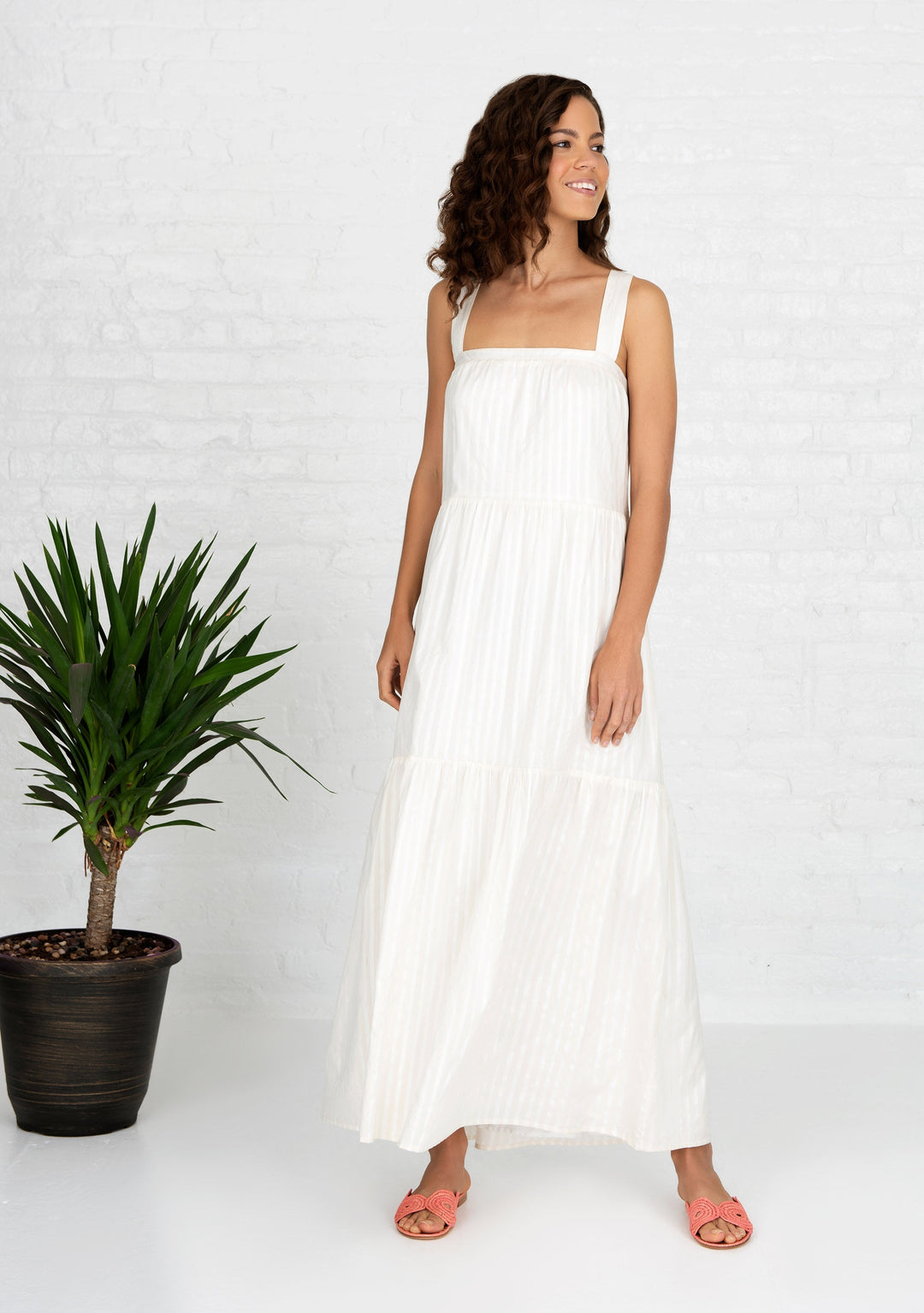 woman next to plant wearing white sleeveless cotton silk blend dress